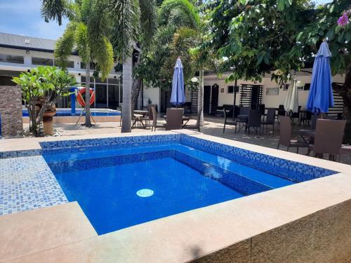 ein blauer Pool mit Stühlen und Sonnenschirmen in der Unterkunft Villa Angelica Private Resort and Venue in San Juan