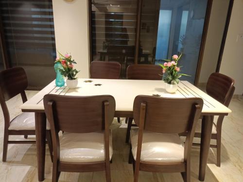 a dining room table with chairs and flowers on it at Anant in Jāmb