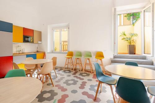 a room with tables and chairs and a kitchen at Il Genio - Residenza D'Epoca in Pisa