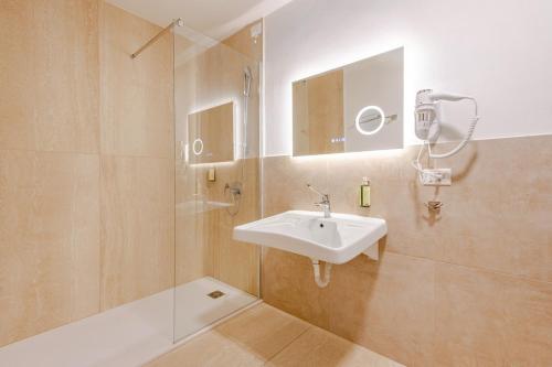 a bathroom with a sink and a mirror and a shower at Il Genio - Residenza D'Epoca in Pisa