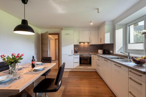 a kitchen with a wooden table and a dining room at Appartement "Am Brummelbach" in Westendorf