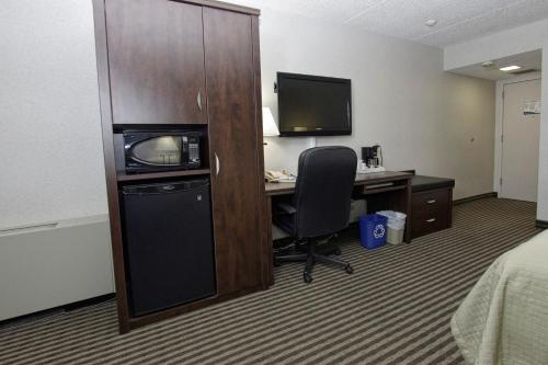 a hotel room with a desk with a computer and a television at Victoria Inn Hotel & Convention Centre Brandon in Brandon