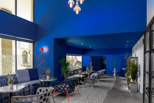 a room with blue walls and tables and chairs at Fresh Hotel, a member of Design Hotels in Athens