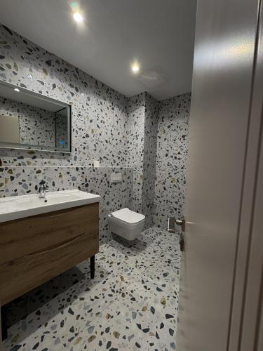 un baño con lavabo e inodoro en Bel Room, en Korçë