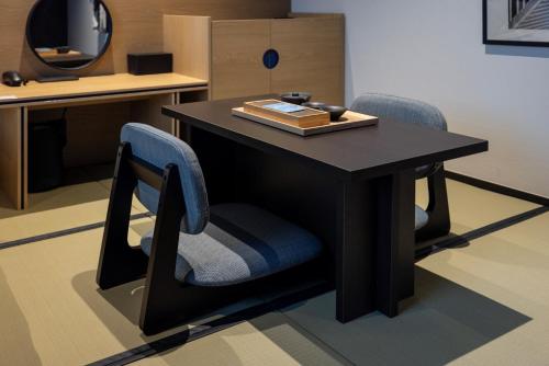 a desk with two chairs and a table with a book on it at Mitasuya Ryokan Hotel by Aank Cheonan in Cheonan