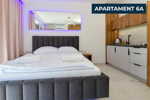 a bedroom with a large bed and a kitchen at Słoneczne Wzgórze Zator in Zator