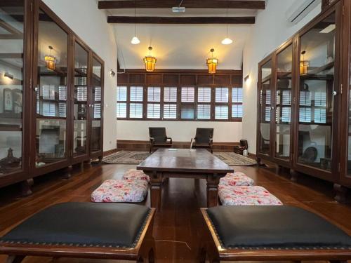 a large room with a table and chairs and windows at East Indies Mansion in George Town