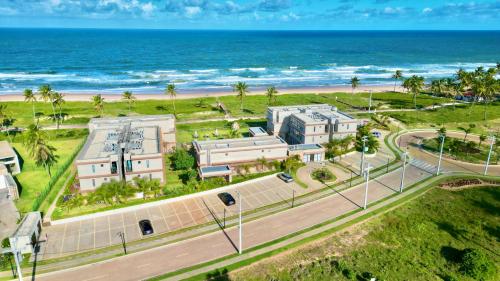 an aerial view of a building near the beach at Apartamento Pé na Areia Cond Alphaville Guarajuba in Camaçari