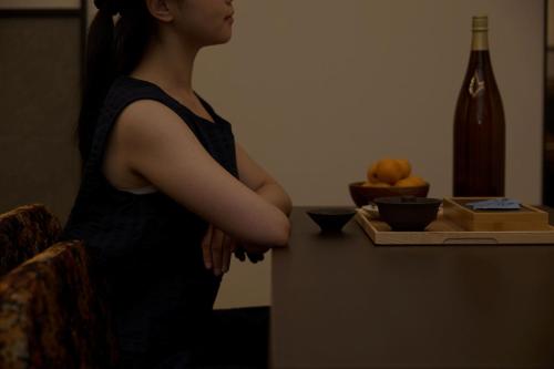 a woman standing next to a counter with her arms crossed at Mitasuya Ryokan Hotel by Aank Cheonan in Cheonan