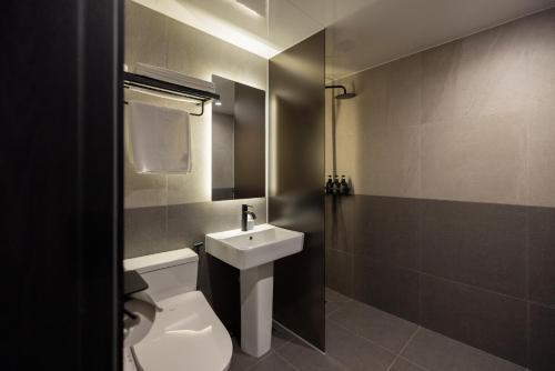 a bathroom with a white toilet and a sink at Mitasuya Ryokan Hotel by Aank Cheonan in Cheonan