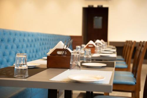 a row of tables with plates and glasses on them at ZiP By Spree Hotels Pandharpur in Pandharpur