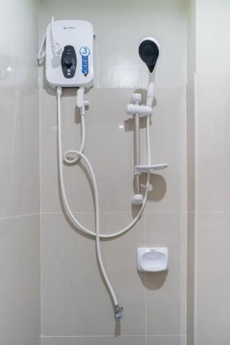 a shower in a bathroom with a hair dryer at Chateau Cinco Near SM Lanang in Davao City