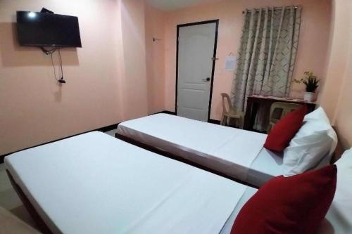 two beds in a room with a tv and a bed sidx sidx sidx at Chateau Cinco Near SM Lanang in Davao City
