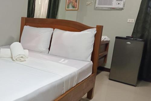 a bed with white sheets and pillows in a room at Chateau Cinco Near SM Lanang in Davao City