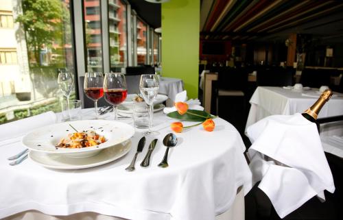 a table with a plate of food and wine glasses at Hotel Metropolis in Andorra la Vella