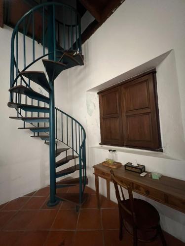 a spiral staircase in a room with a wooden table at East Indies Mansion in George Town
