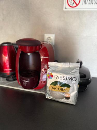 a red coffee maker and a bag of food on a counter at Akrotiri Luxury Suites in Trápeza
