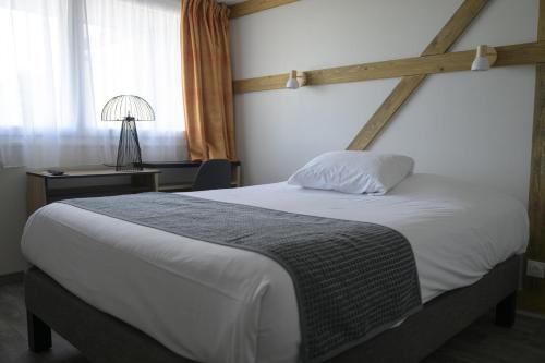 a bedroom with a large white bed and a window at Hôtel Restaurant Au Relais D'Alsace in Rouffach
