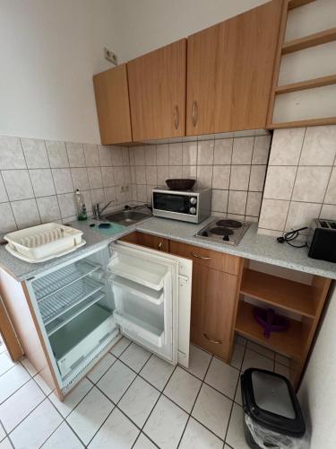 a kitchen with an open refrigerator and a microwave at Kleine gemütliche Wohnung Pfortnerstraße 23 in Niederdorla