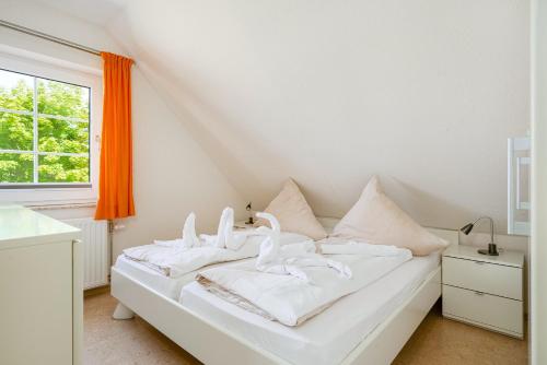 a white bed with swans on it in a room at Knut in Greetsiel