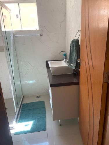 a small bathroom with a sink and a shower at Royal Lion Bedroom in Londrina