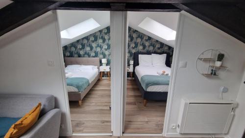 a bedroom with two beds and a couch at Cocon sous les toits By UnSejourANancy Fr in Nancy