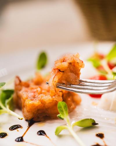 a fork eating a piece of food on a plate at Villa Mosca Charming House in Alghero