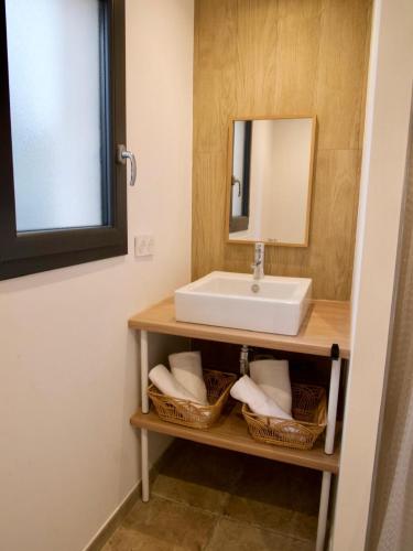 a bathroom with a sink and baskets at Hotel Clair de Lune in Zonza