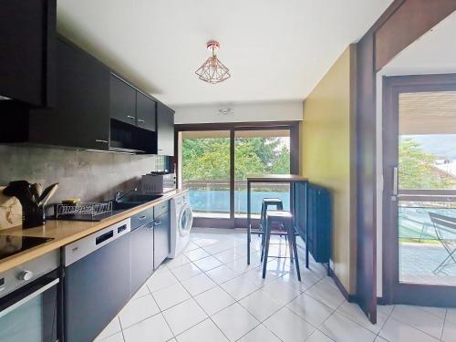 - une cuisine avec un évier et un comptoir avec une table dans l'établissement Cristal de Roche CI2 CALME & MOUNTAIN 8 Pers, à Châtel