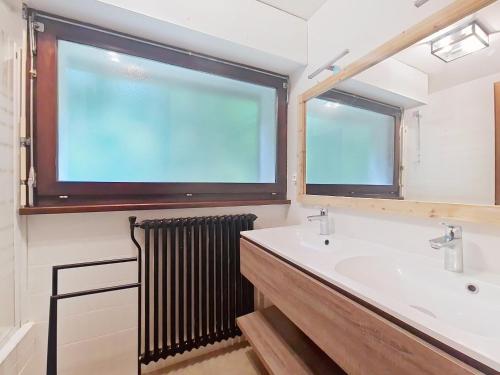 une salle de bain avec un lavabo et une grande fenêtre dans l'établissement Cristal de Roche CI2 CALME & MOUNTAIN 8 Pers, à Châtel
