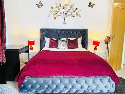 a bedroom with a large bed with a red blanket at Igloo Magnolia Room Stay I Breakfast I Free Parking in Leeds