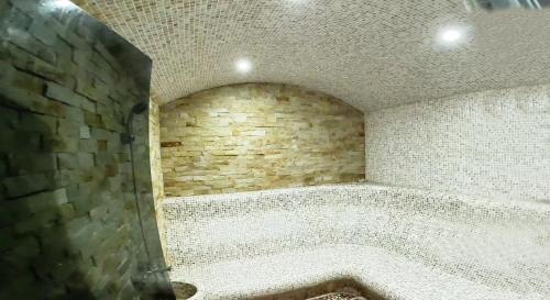 a room with a stone wall and a bath tub at Hotel Pliska All inclusive in Golden Sands