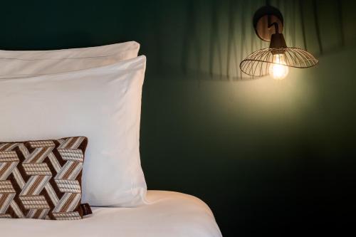 a bedroom with a bed with a pillow and a light at 9Hotel Opera in Paris