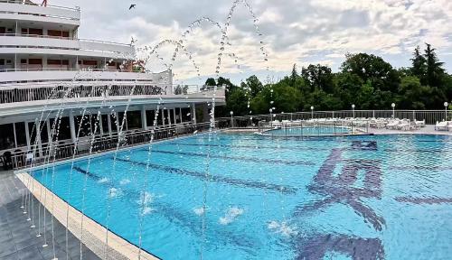 a large swimming pool next to a cruise ship at Hotel Pliska All inclusive in Golden Sands