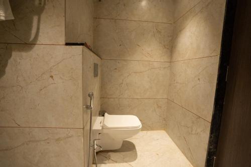 a bathroom with a toilet in a stone wall at ZiP By Spree Hotels Pandharpur in Pandharpur