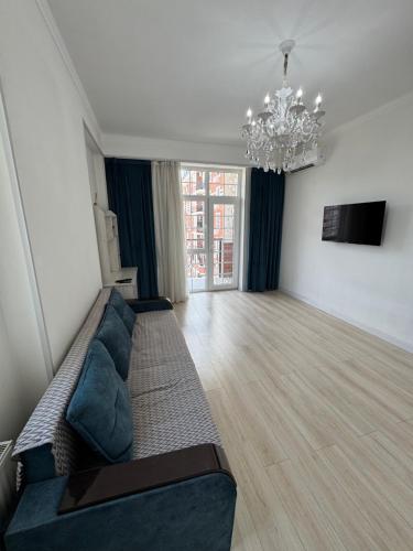a living room with a couch and a chandelier at Greenwich Apartments in Tashkent in Tashkent