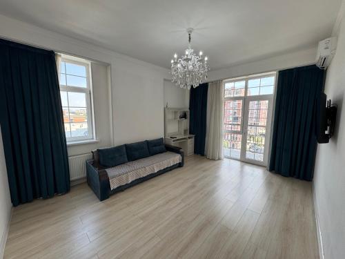 a living room with a couch and two windows at Greenwich Apartments in Tashkent in Tashkent