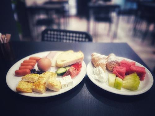 two plates of food sitting on a table at New Amaryllis Hotel in Athens