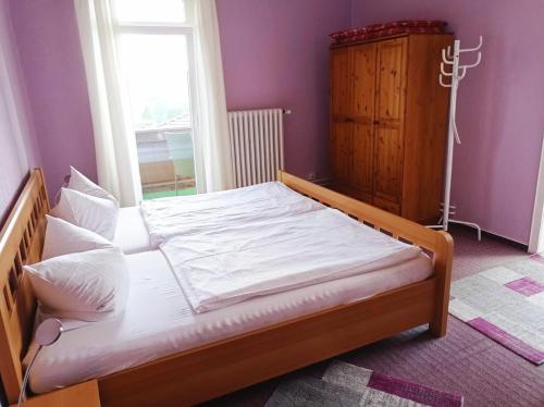 a bed in a room with a large window at Pension Sonnenhof in Braunlage