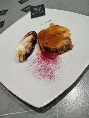 a white plate with a piece of food on it at Hotel Hypnos in San Giorgio Montagna