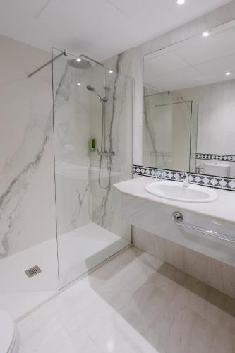 a white bathroom with a shower and a sink at Civis Jaime I in Castellón de la Plana