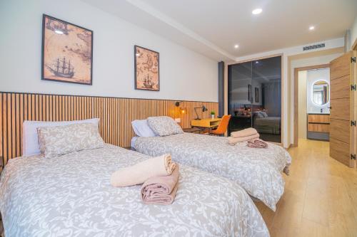 a bedroom with two beds with towels on them at CARTAGENAFLATS - San Diego Suites in Cartagena