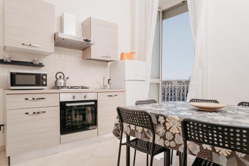 a kitchen and dining room with a table and chairs at Central Station by CasaNapoletana in Naples