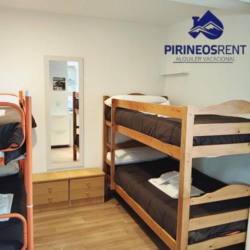 a dorm room with bunk beds and a mirror at Apartamentos Pirineos Rent in Candanchú
