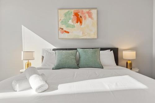 Un dormitorio con una cama blanca con dos lámparas. en Beautiful 3 bedroom oasis close to downtown, en Austin