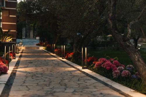 a stone walkway with flowers in a park at Giardino Lux Apartments in Ulcinj