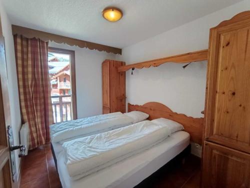 une chambre avec deux lits et une fenêtre dans l'établissement Grand T3 plein sud avec garage couvert et accès direct aux pistes - FR-1-445-177, à Montgenèvre