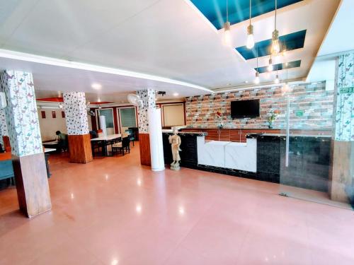 a living room with a brick wall and a tv at Hotel The Apex,Jaipur in Jaipur