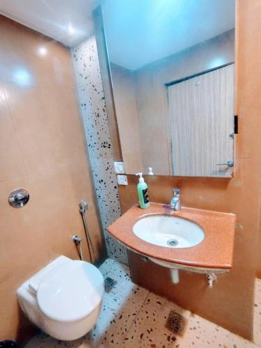 a bathroom with a sink and a toilet and a mirror at Hotel The Apex,Jaipur in Jaipur