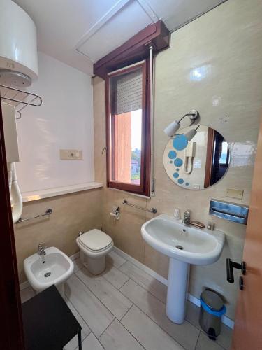 a bathroom with a sink and a toilet and a mirror at Nouvel Hotel Des Bains in Pesaro